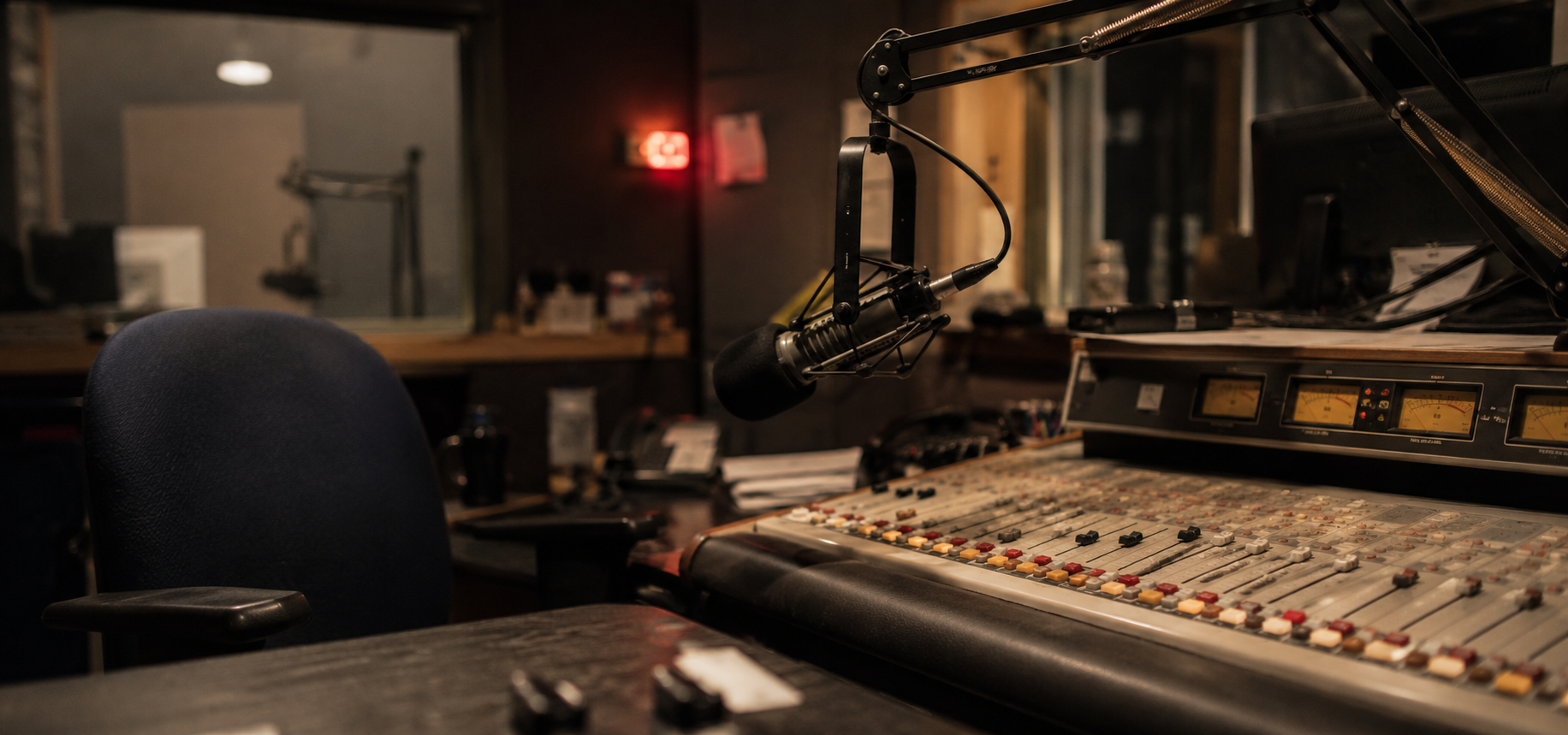 Radio broadcast studio with microphone, mixing board, and on-air light